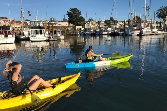 a group of people in a small boat in a harbor